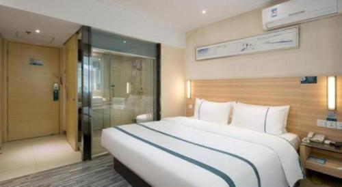 a large white bed in a hotel room at City Comfort Inn Hengyang Shigu Shuyuan in Hengyang