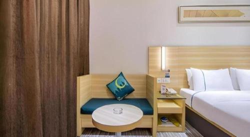 a hotel room with a bed and a table at City Comfort Inn Shantou Daxue Road in Shantou