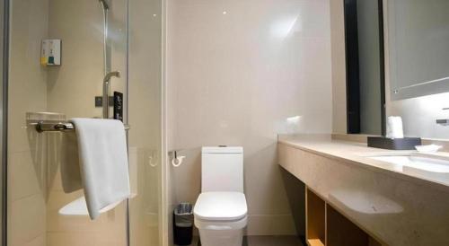a bathroom with a toilet and a sink at City Comfort Inn Beiliu Yongfeng Plaza Chengnan Bus Station in Yulin