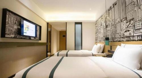a hotel room with two beds and a flat screen tv at City Comfort Inn Beiliu Yongfeng Plaza Chengnan Bus Station in Yulin