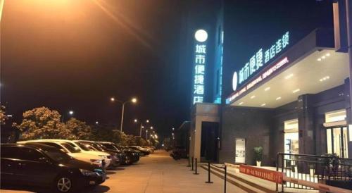 a parking lot with cars parked in front of a building at City Comfort Inn Yingcheng Railway Station Shanghe Square in Xiaogan