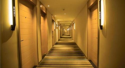 a long hallway with tile floors and lights at City Comfort Inn Yingcheng Railway Station Shanghe Square in Xiaogan