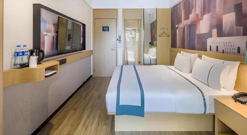 a large white bed in a room with a television at City Comfort Inn Liuzhou Wuling Liutai Road in Liuzhou