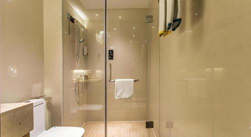 a bathroom with a glass shower with a toilet at City Comfort Inn Liuzhou Wuling Liutai Road in Liuzhou