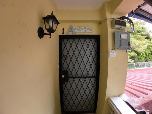 a door with a light on the side of a building at Sana El Jardin Secreto in Santiago de los Caballeros