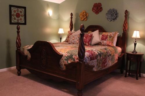 a bedroom with a large wooden bed with pillows at Maple Creek Bed&Breakfast in Tomball