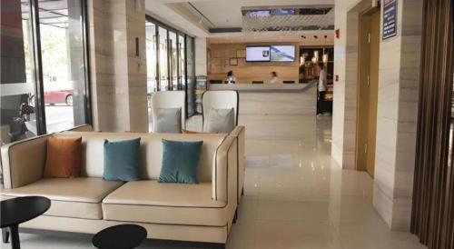 a lobby with a couch with blue pillows on it at City Comfort Inn Hainan Tunchang Changsheng Road 
