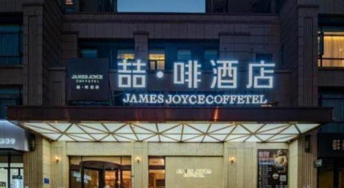 a building with a sign on the front of it at James Joyce Coffetel Luoyang Longmen High-speed Railway Station Baolong Plaza in Luoyang