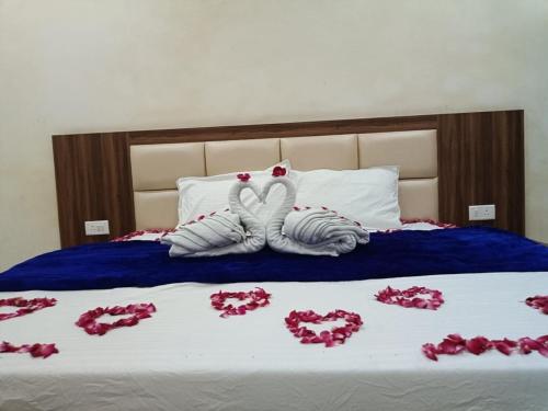 two towels in the shape of hearts are on a bed at Hotel lucky guest house in Jhānsi