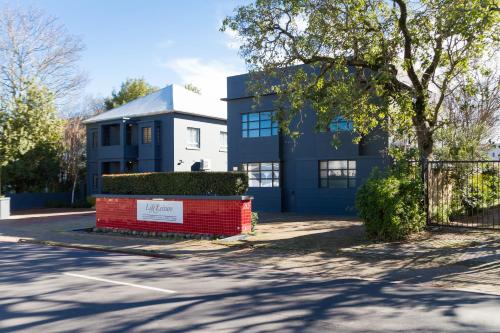 a blue and white house with a red wall at Life & Leisure Boutique Guesthouse in Stellenbosch