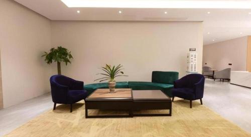 a living room with a green couch and blue chairs at Green Tree Inn Nanchang Zhongshan Road Bayiguan in Nanchang