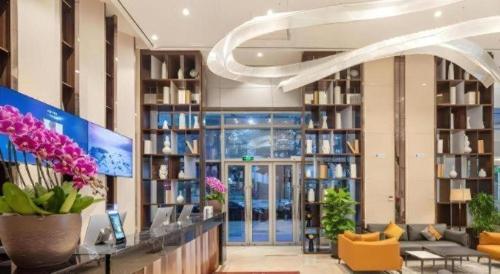 a lobby of a library with flowers and books at VX Hotel Wuxi Xinwu District Executive Center Wanda Plaza in Wuxi