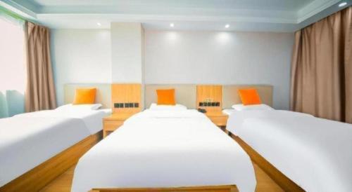 two twin beds in a room with orange at Shell Hotel Wuhu Jiujiang District Daqiao Town Huashan Road in Wuhu