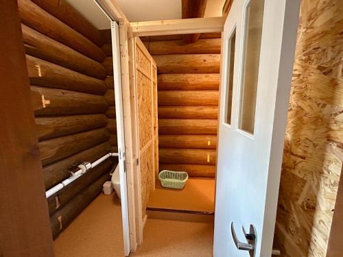 a door leading into a bathroom with wooden walls at Mashuko Youth Hostel - Vacation STAY 01026v in Teshikaga