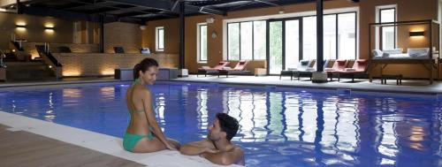 2 personnes assises dans une piscine dans l'établissement Clos des Glycines, à Lésigny