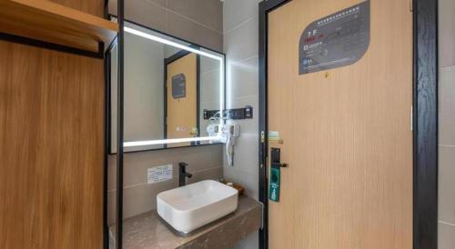 a bathroom with a sink and a mirror at GreenTree Inn Express Lanzhou West Passenger Station Lanzhou Center in Lanzhou