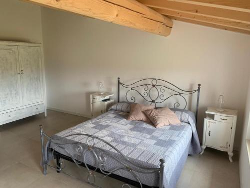 a bedroom with a metal bed with two pillows on it at Agriturismo Corte Bonetti - Appartamento Il Salice in Pescantina
