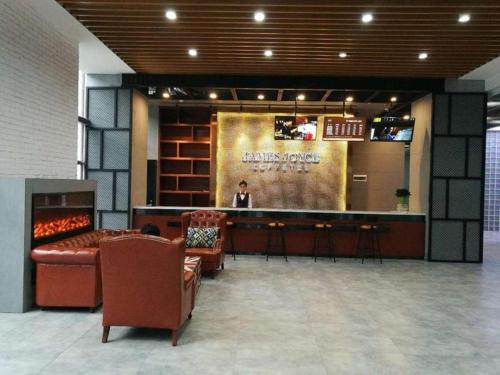 a lobby with a bar with a man on a screen at James Joyce Coffetel Wuhan Gutian Er Road Metro Station in Wuhan