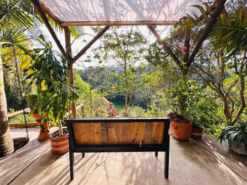 a wooden bench sitting on a porch with plants at Ecohotel campestre Rionegro-A 20 minutos del aeropuerto in Rionegro