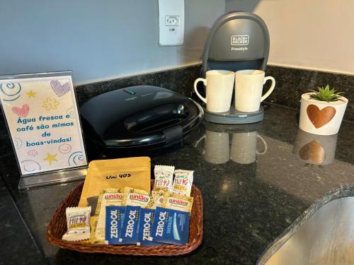 a basket of food sitting on a counter next to a coffee maker at Studio moderno e novo - Uni Home 405 - Boa Viagem in Niterói
