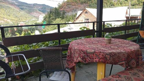 a table and chairs on a balcony with a view at Ksenia's apartment in Borjomi