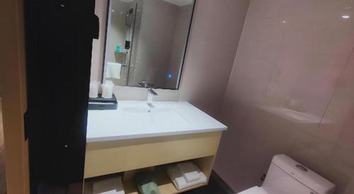 a bathroom with a sink and a toilet and a mirror at City Comfort Inn Changsha South Railyway Station West Square in Changsha
