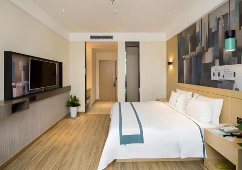 a bedroom with a large white bed and a television at City Comfort Inn Changsha South Railyway Station West Square in Changsha