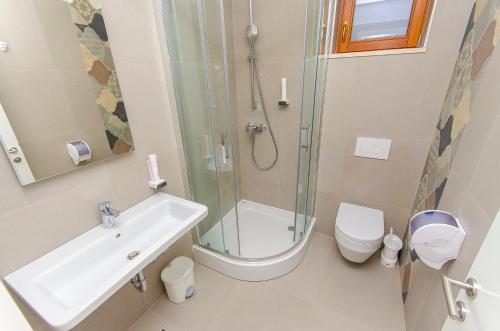a bathroom with a toilet, sink, and shower at Hostel Dvor in Split