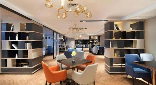 a dining room with a table and chairs and shelves at Echarm Hotel Shenyang Zhongjie North Station Metro Station in Shenyang