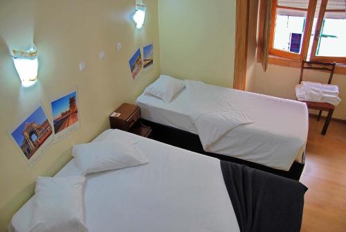 two beds in a hotel room with two beds at Norte Guest House in Lisbon
