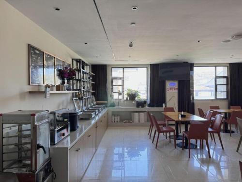a kitchen with a table and chairs and a kitchen with a counter at City Comfort Inn Shiyan Wudang Mountain in Danjiangkou