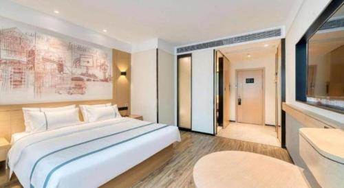 a bedroom with a large white bed and a large window at City Comfort Inn Lijiang Ancient Town in Lijiang