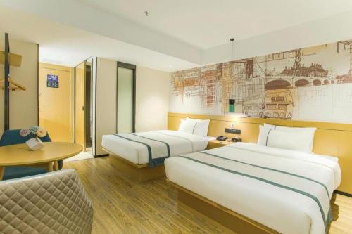 a hotel room with two beds and a table at City Comfort Inn Lijiang Ancient Town in Lijiang