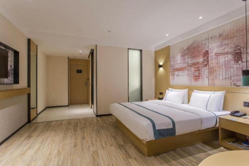 a hotel room with a large bed and a desk at City Comfort Inn Lijiang Ancient Town in Lijiang