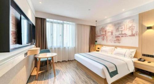 a hotel room with a large bed and a table at City Comfort Inn Lijiang Ancient Town in Lijiang