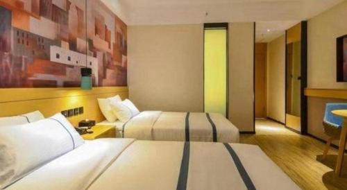 a hotel room with two beds and a couch at City Comfort Inn Lijiang Ancient Town in Lijiang