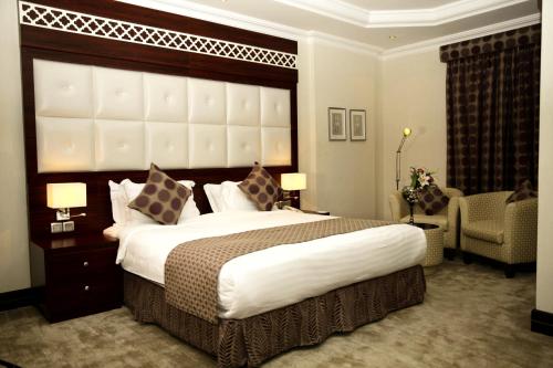 a bedroom with a large bed with a large headboard at Dalin Hotel in Riyadh