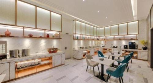 a large kitchen with a table and chairs at Magnotel Hotel Xiamen North Station Binhai in Xiamen