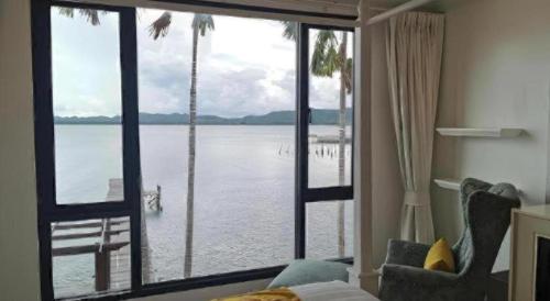 a room with a large window with a view of the water at AT Kung Kra baen Hotel and Residence in Chanthaburi