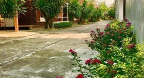 a street with flowers in front of a house at Kidthuengpark in Si Racha