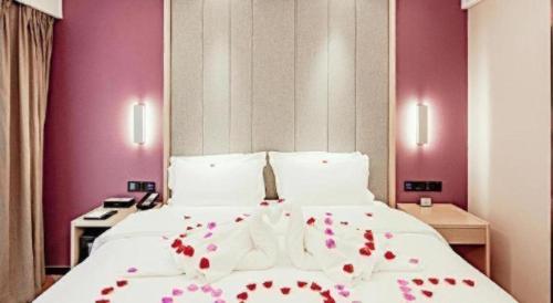 a bedroom with a large white bed with red flowers on it at Lavande Hotel Changsha South High-speed Railway Station Xiyingmen in Changsha