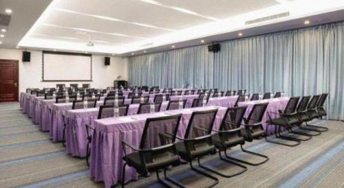 a banquet hall with purple tables and chairs and a screen at Lavande Hotel Zhongshan Xiaolan Taifeng in Jilong