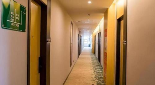 a long hallway with yellow and white walls at GreenTree Inn Express Chuzhou Langya District Government Chuhe Road in Chuzhou