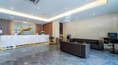 a lobby with a couch and a table in a building at GreenTree Inn Express Hebei Tangshan Guyan District Xinguang Road in Tangshan