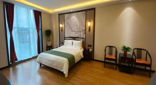 a bedroom with a bed and a table and chairs at GreenTree Inn Express Datong High-Speed Railway Station Wanda Plaza Fangte in Datong