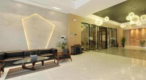 a lobby with a couch and a table in a building at VX Hotel Chengdu Shuangliu Airport Sainawei in Chengdu