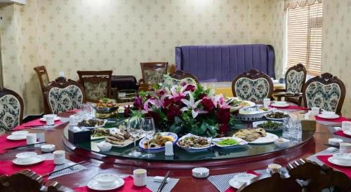 a table with plates of food and flowers on it at Green Tree Inn Tibet Lhasa Zhaji Temple in Lhasa