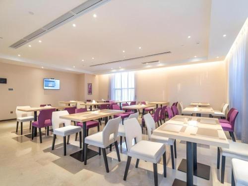 a dining room with tables and purple chairs at Lavande Hotel Huizhou Shiwan in Huizhou