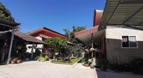a courtyard of a house with plants and flowers at HotelBanAunirukChiangrai in Chiang Rai