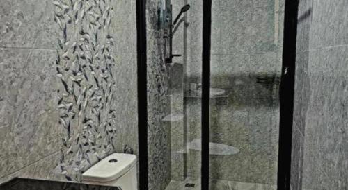 a bathroom with a shower with a toilet and a sink at HotelBanAunirukChiangrai in Chiang Rai